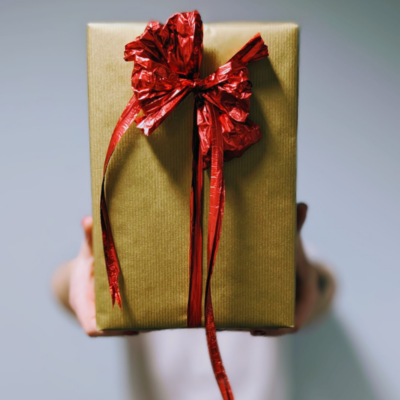 Kuldne kingipakk punase paela ja lipsuga